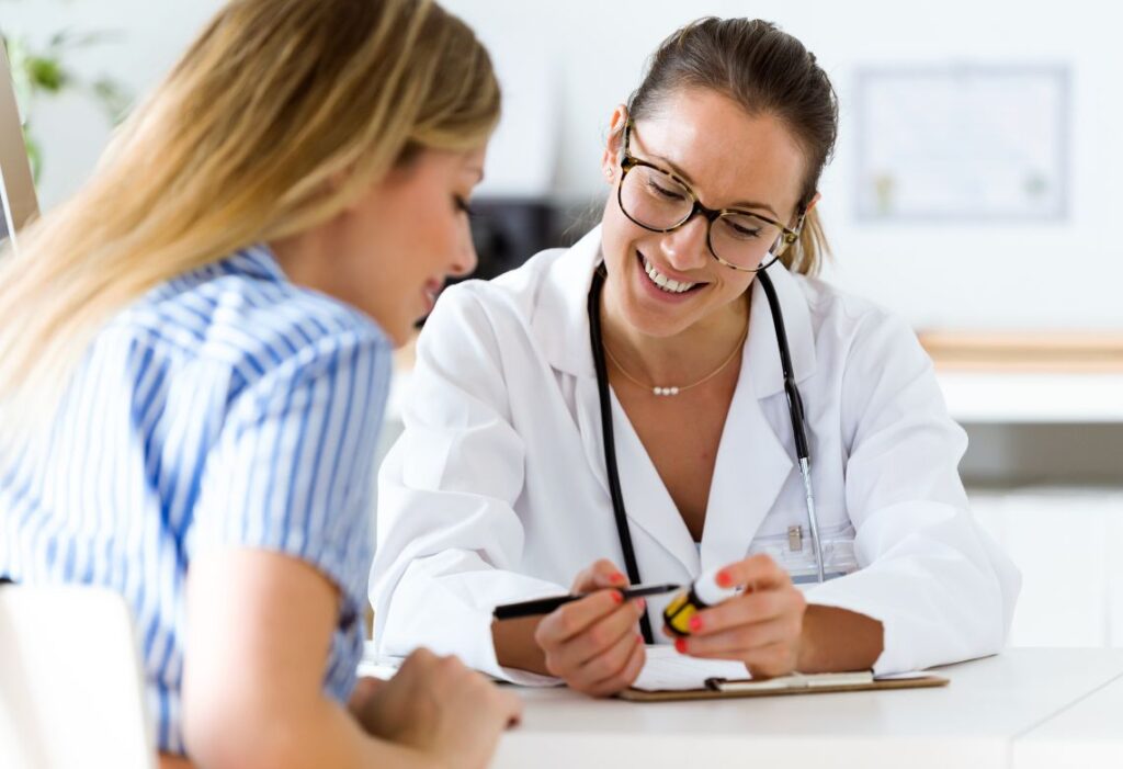 Mulher sendo orientada pela sua médica em um consultório
