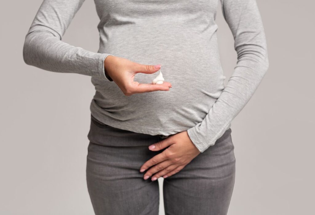 mulher gravida com um creme branco pastoso na mão