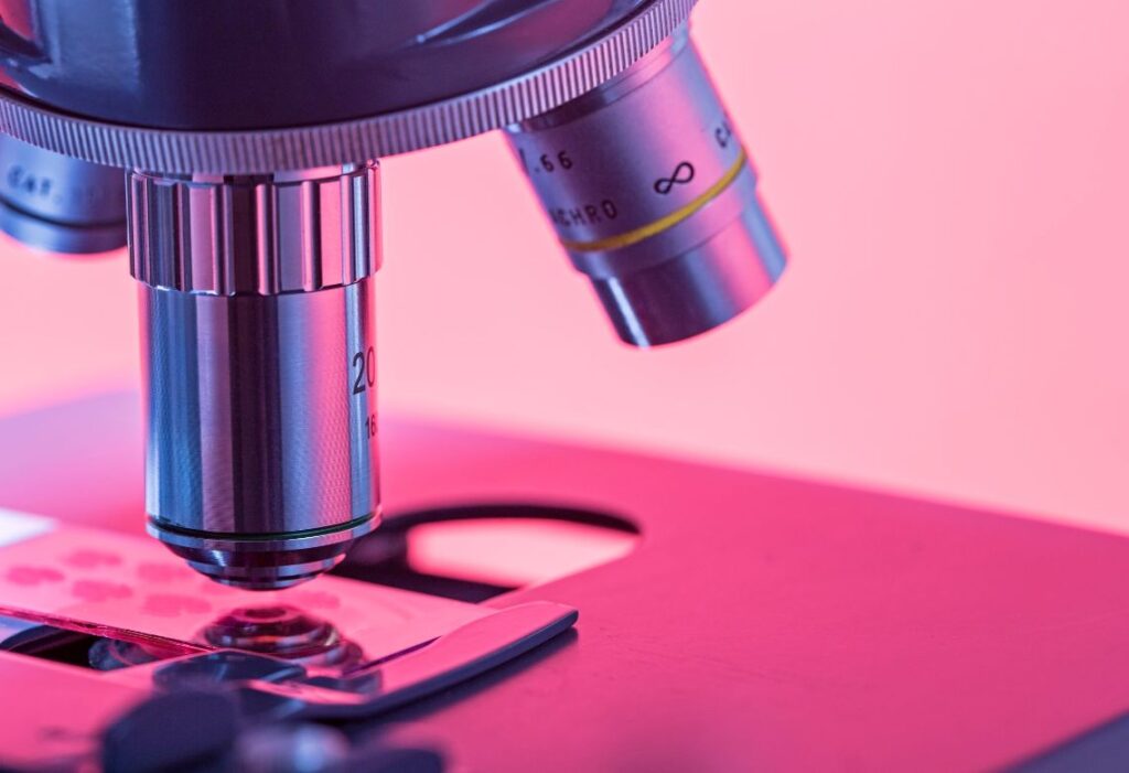 Microscópio em foto com tonalidade rosada
