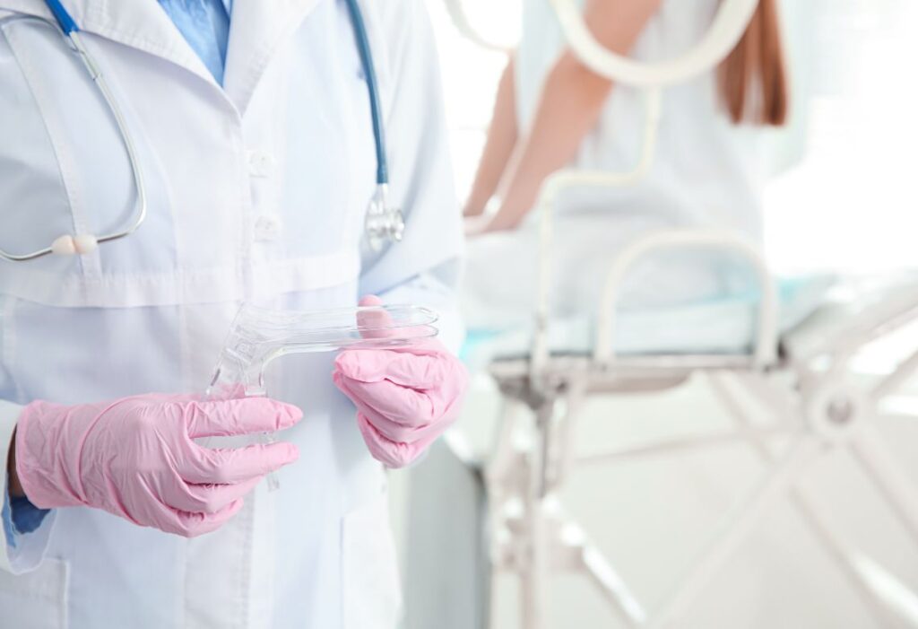 Médica com especulo na mão para examinar a paciente